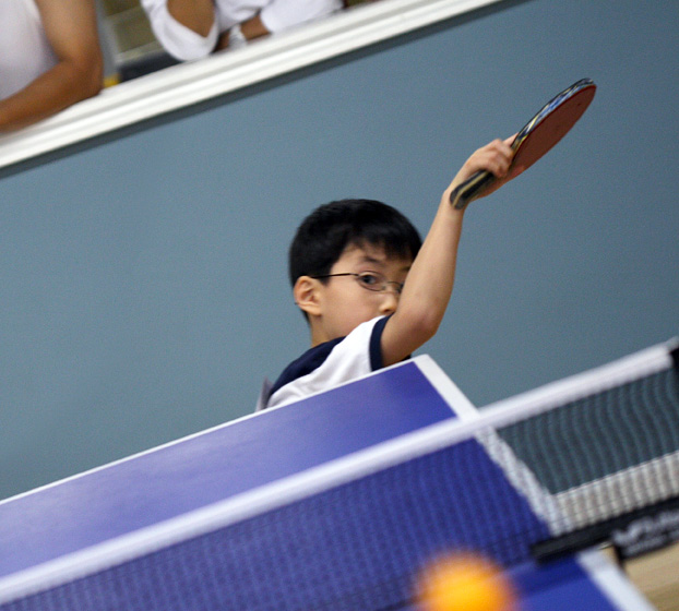 boy hits table tennis ball